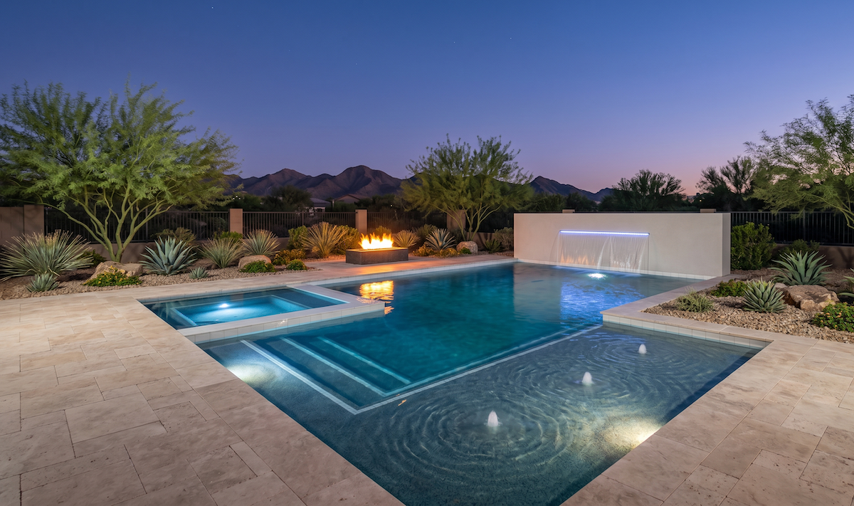 Luxury backyard at dusk featuring a swimming pool with a built-in spa, a waterfall wall, and a modern fire pit.
